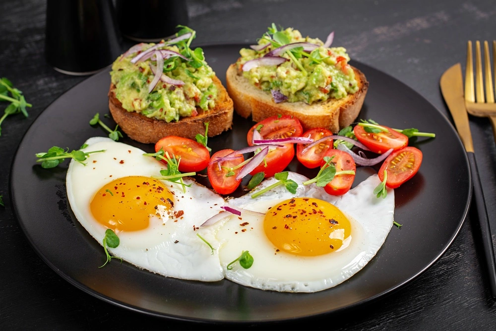 Bữa sáng với trứng, bánh mì và bơ là thức ăn nhiều protein đơn giản, dễ chuẩn bị giúp bạn no lâu và bắt đầu ngày mới đầy năng lượng.